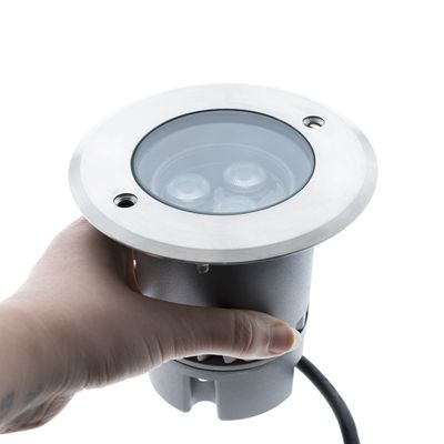 Ulkokäyttöön tarkoitettu LED-valaisin ruostumattomasta teräksestä valmistetulla reunalla, lasikansi henkilön hallussa; Siinä on 3 sisäistä lamppua energiatehokkaaseen valaistukseen.